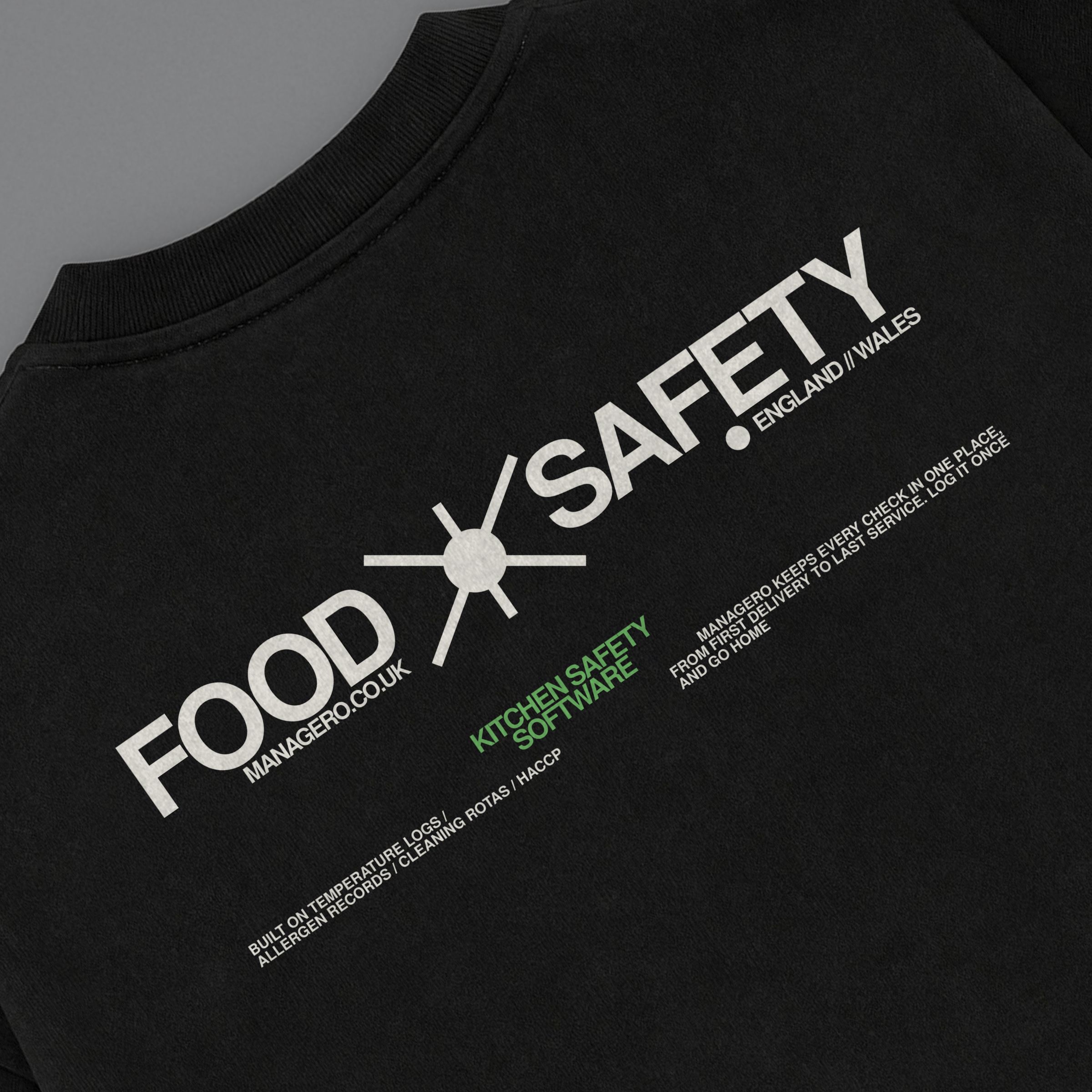 Black FOOD SAFETY T-Shirt: close-up of the FOOD SAFETY back print, the tee laid at an angle